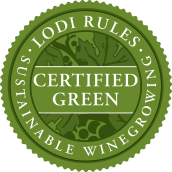 Scenic view of Berryhill Family Vineyards with lush grapevines under a clear sky, showcasing sustainable farming practices.